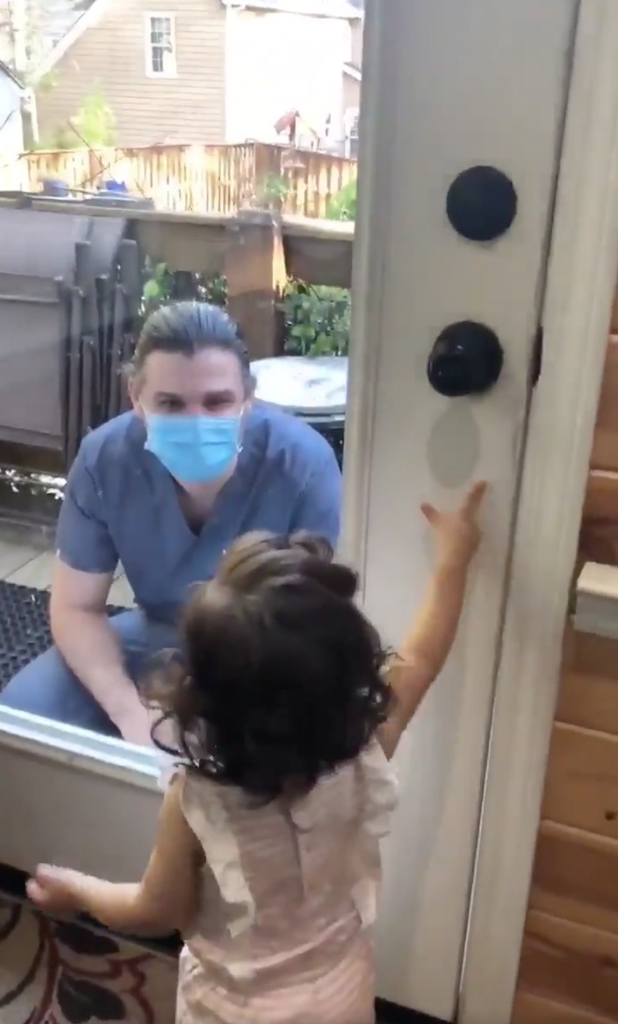 一名醫生爸爸站在家門前，隔著玻璃與女兒飛吻，女兒想開門迎接爸爸不果，於是哭了起來，令人非常心酸。