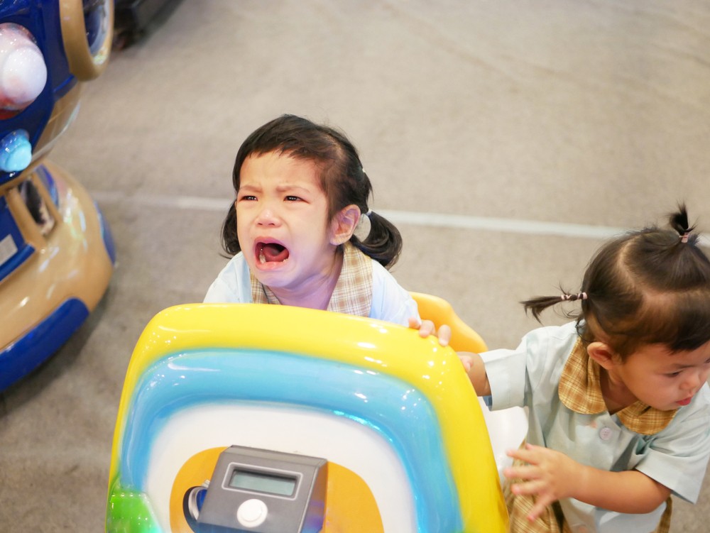 孩子跟其他人爭玩具。