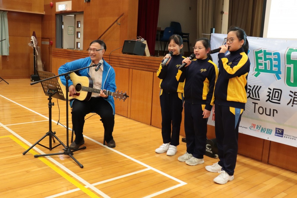 崔校長與學生一起又彈又唱。