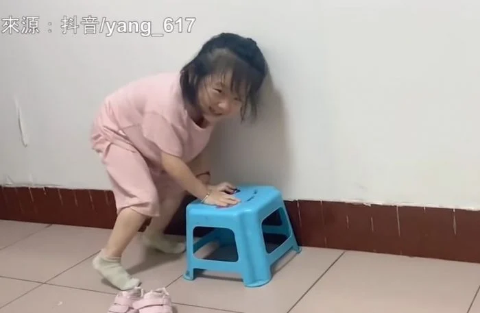 她在房間換完睡衣後步履不穩地走出來,自信十足地拿著一雙鞋子。