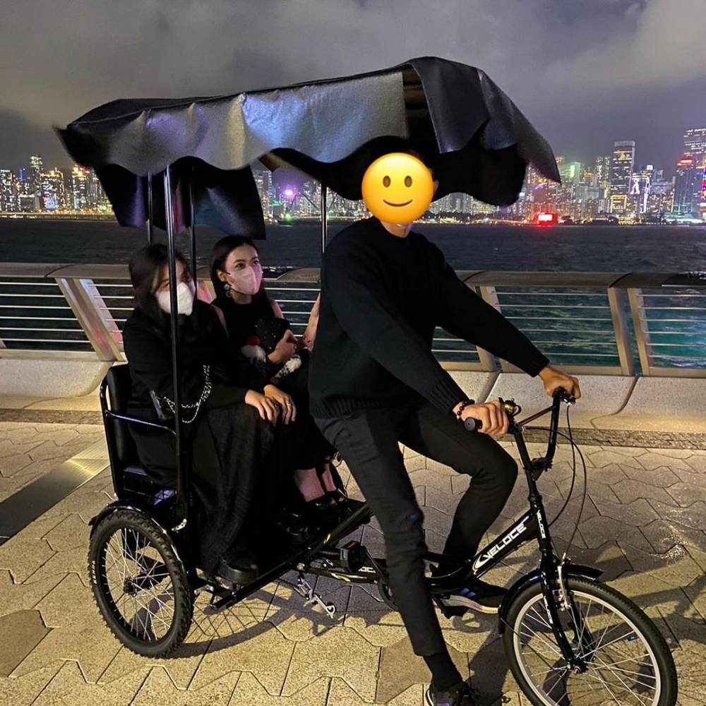 兩人身穿一身貴氣禮服坐三輪車。