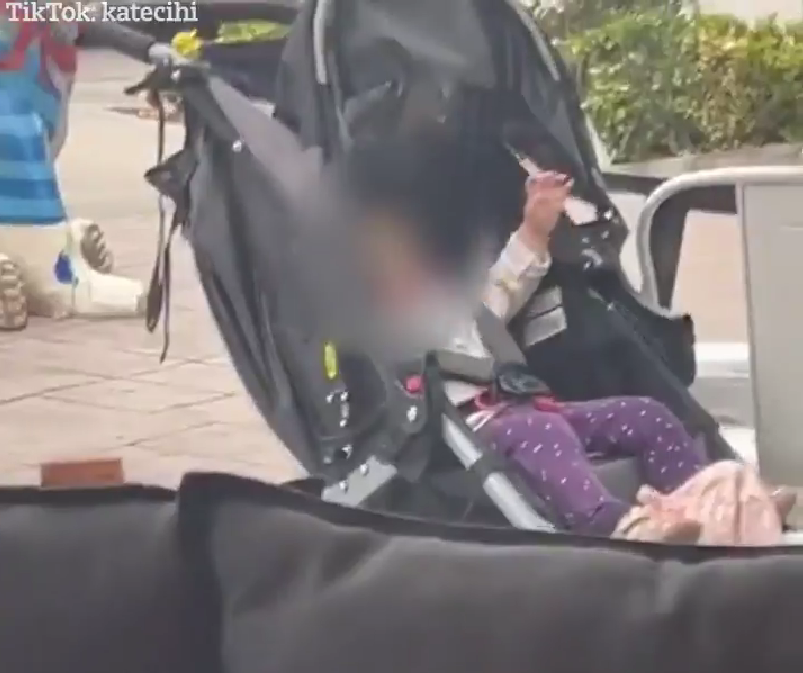 一名母親把嬰兒車及嬰兒留在店外,沒人看守。
