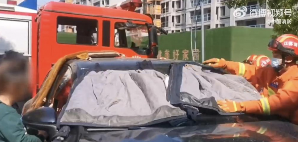 消防員把防火服蓋在車窗上幫孩子遮陰嘗試降溫，並不斷用測溫儀持續觀察車箱溫度。