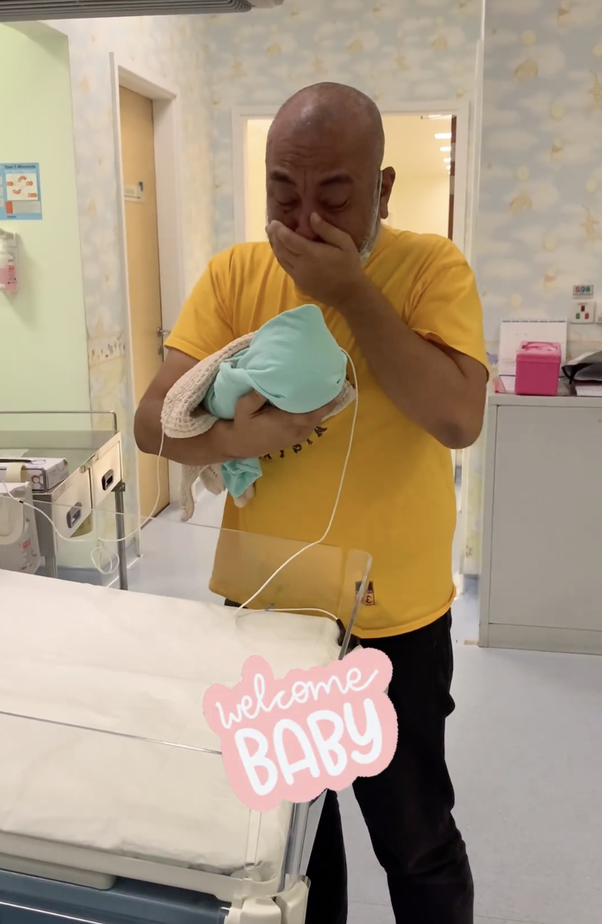 丈夫抱著嬰兒,喜極而泣。