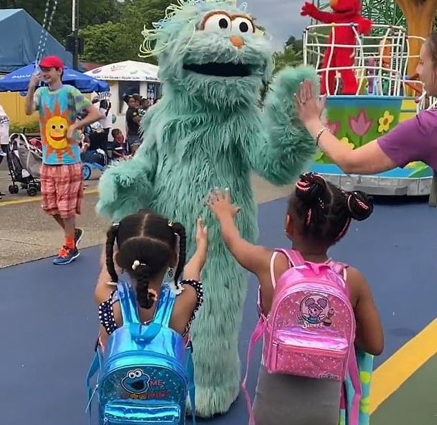 畫面顯示人偶和其他遊客擊掌。