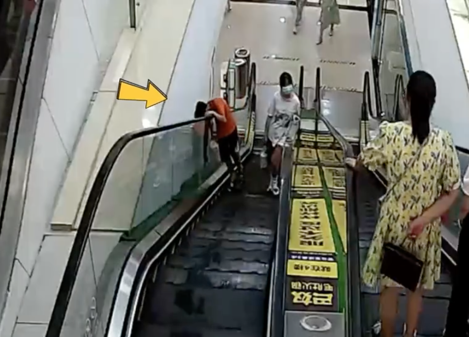 男童將頭部探出扶手電梯向上仰望