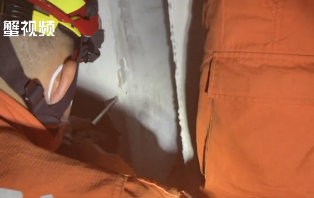 消防員鑿破牆壁，方便救出女童。