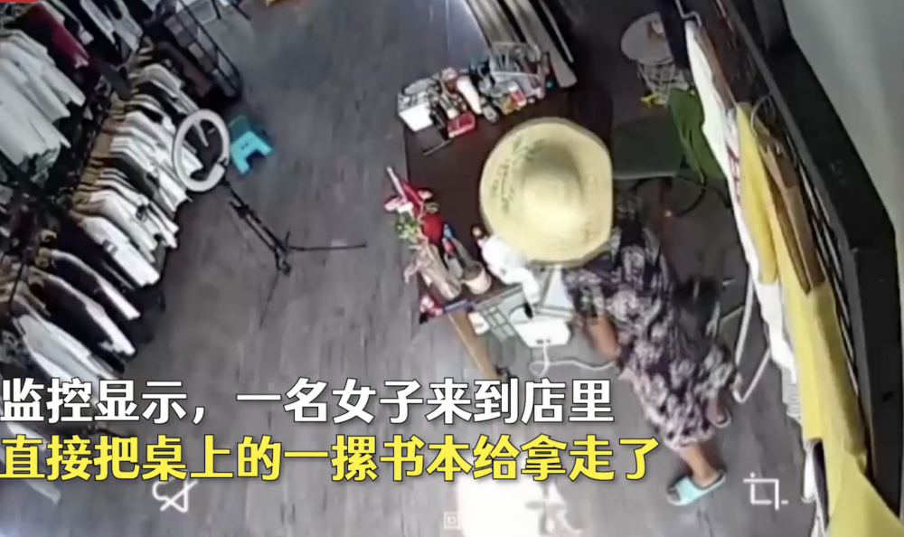 大媽進店後發現沒人注意,就順手拿走桌上的一疊書本。