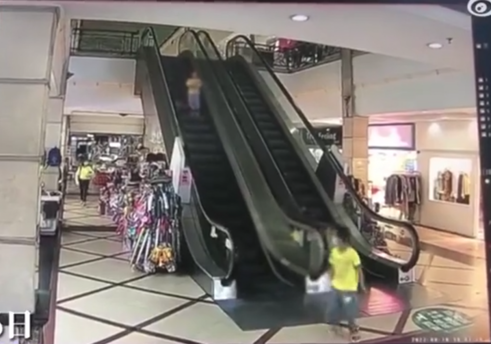 男童快速下電梯後，蹲下按停機掣。