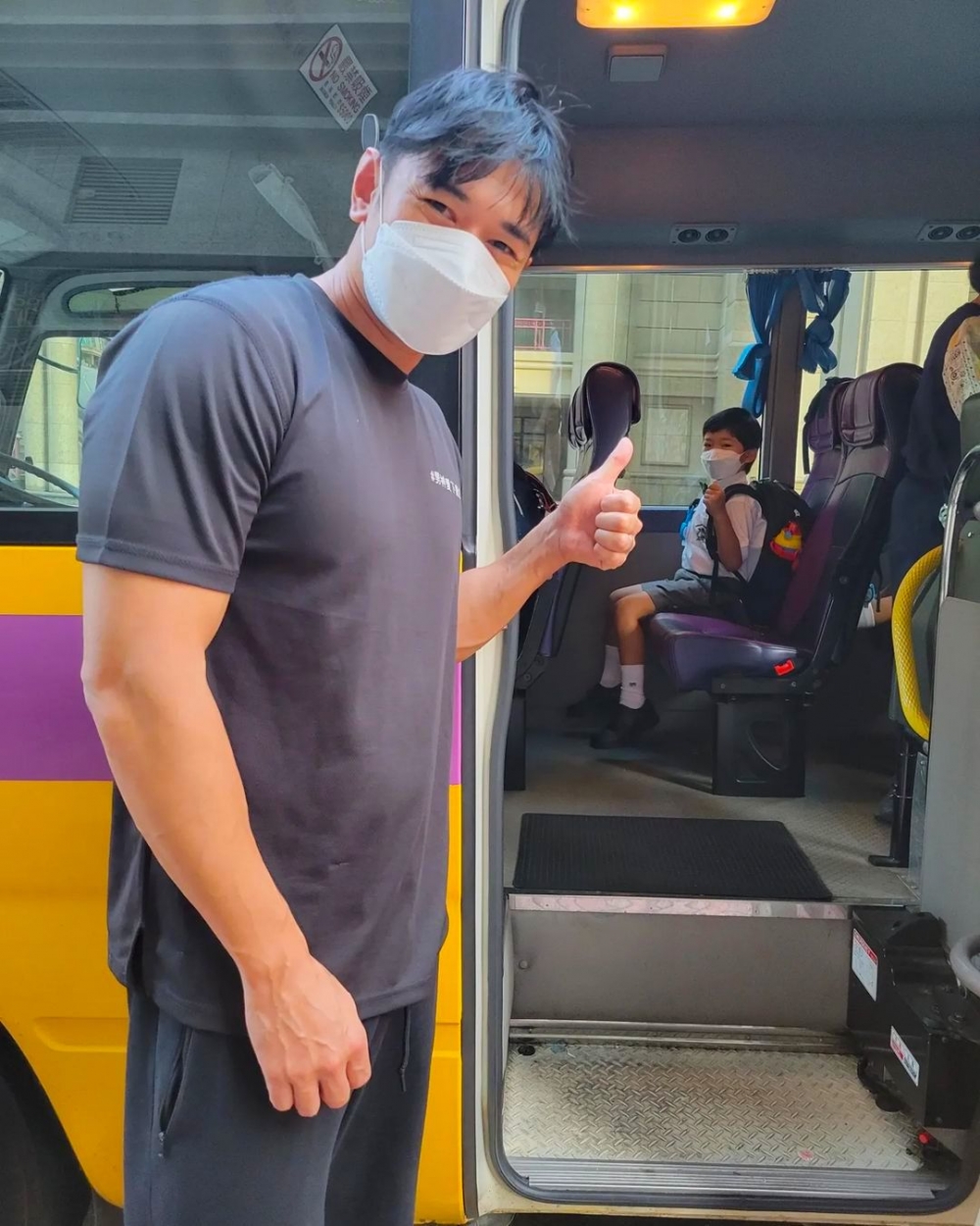 黃祥興目送兒子上校車，依依不捨。