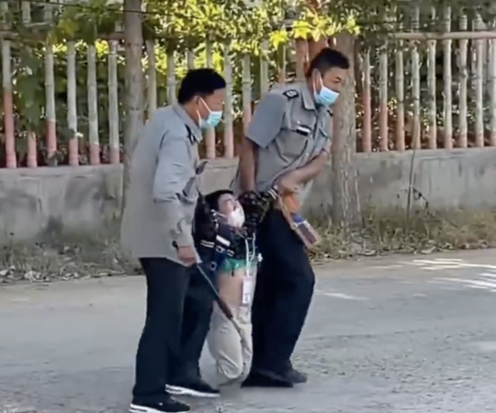 男童被兩名保安大叔架走。