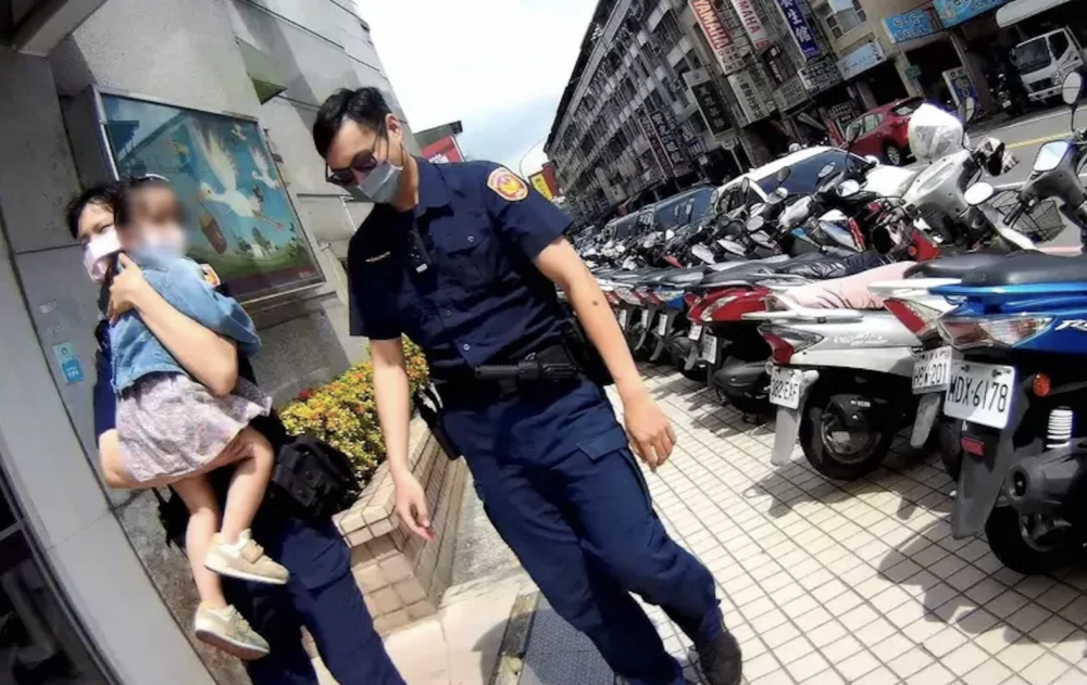 警員輪流抱着女童，沿路為女童找嫲嫲。