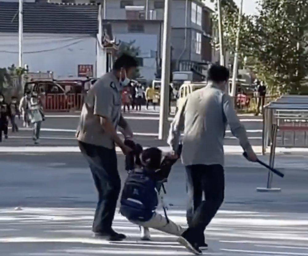 臨入校門前，男童仍不停掙扎。