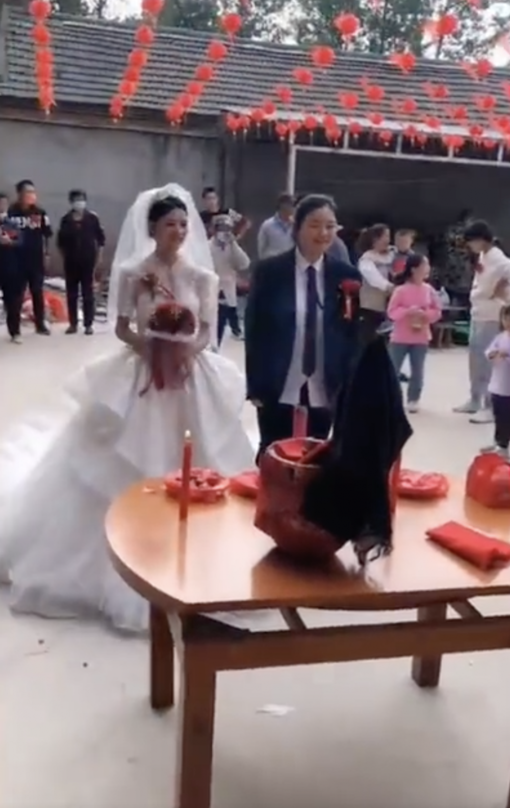 妹妹穿上西裝，代哥哥與阿嫂行禮。