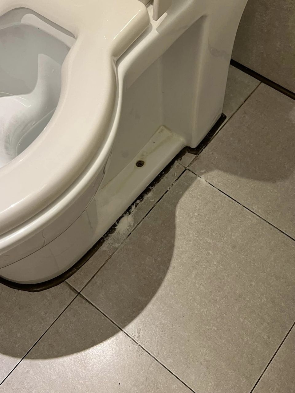 廁所中的馬桶很污糟，旁邊又灑了一攤白白的粉。