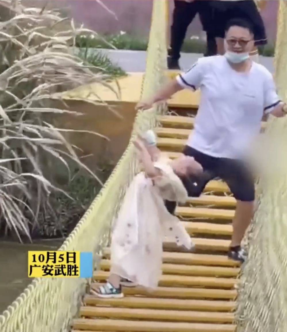 畫面顯示爸爸在後面搖晃橋身，使女兒跟著劇烈搖晃，根本站不穩。