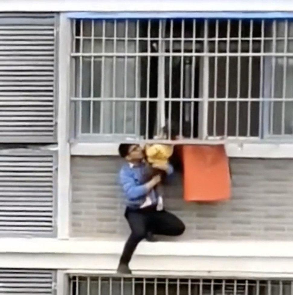 男子成功脫出女童身體,協助她回到窗戶內。