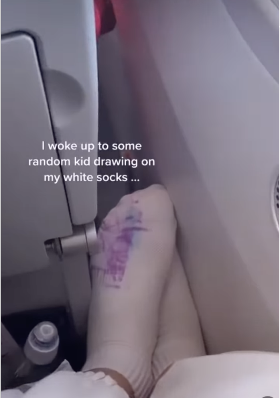 女子將腳放在前方座位扶手上。