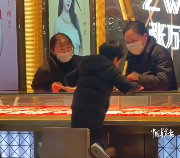 兒子突然走進附近的金鋪，更爬上店內的椅子看起了店內的飾品。