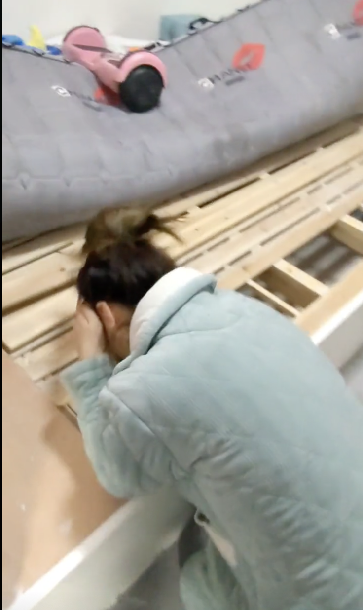 妻子發現丈夫的私房錢，開心得笑倒在床架旁。