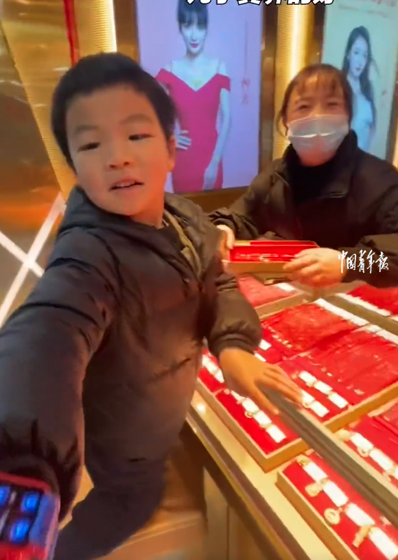 發現兒子正為她挑選金頸鏈，其實兒子本想給媽媽一個驚喜，結果提前被識破。