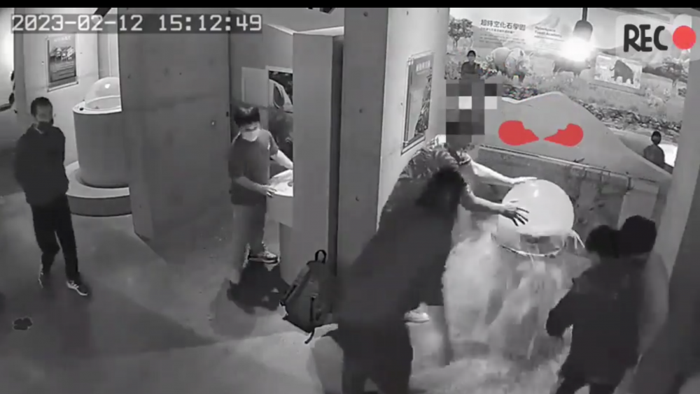 男子搖晃展品後不久,展品隨即破裂,並傾瀉出大量液體,周圍的人都嚇呆。