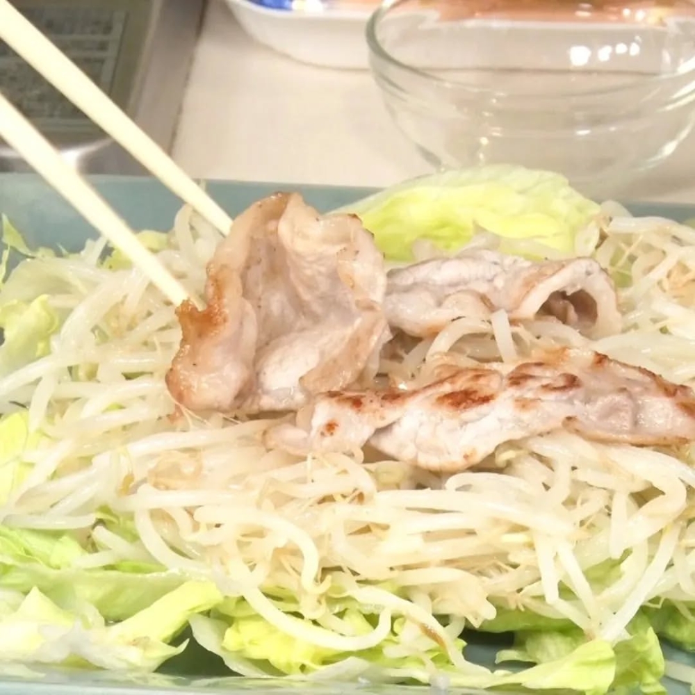 將生菜和芽菜盛入盤中，然後放上豬肉片